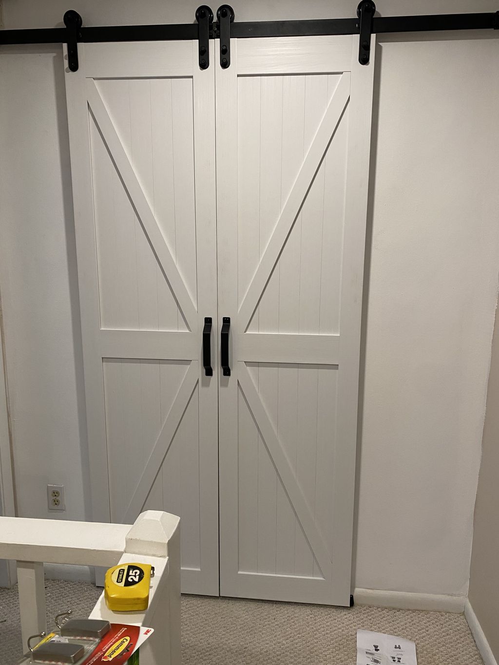 White double barn doors installed on black sliding hardware